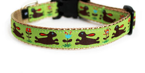 A lime green dog collar featuring a pattern of cute brown rabbits and colorful flowers along its length.