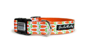 The Carrot Patch Dog Collar with orange webbing and white trim with orange carrots in rows that continue across the length of the collar.