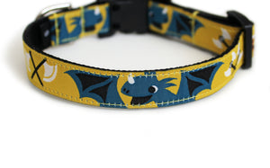 Cute Dog Collar with black webbing and soft, yellow, European trim featuring blue dragons, boy and girl vikings, and axes.